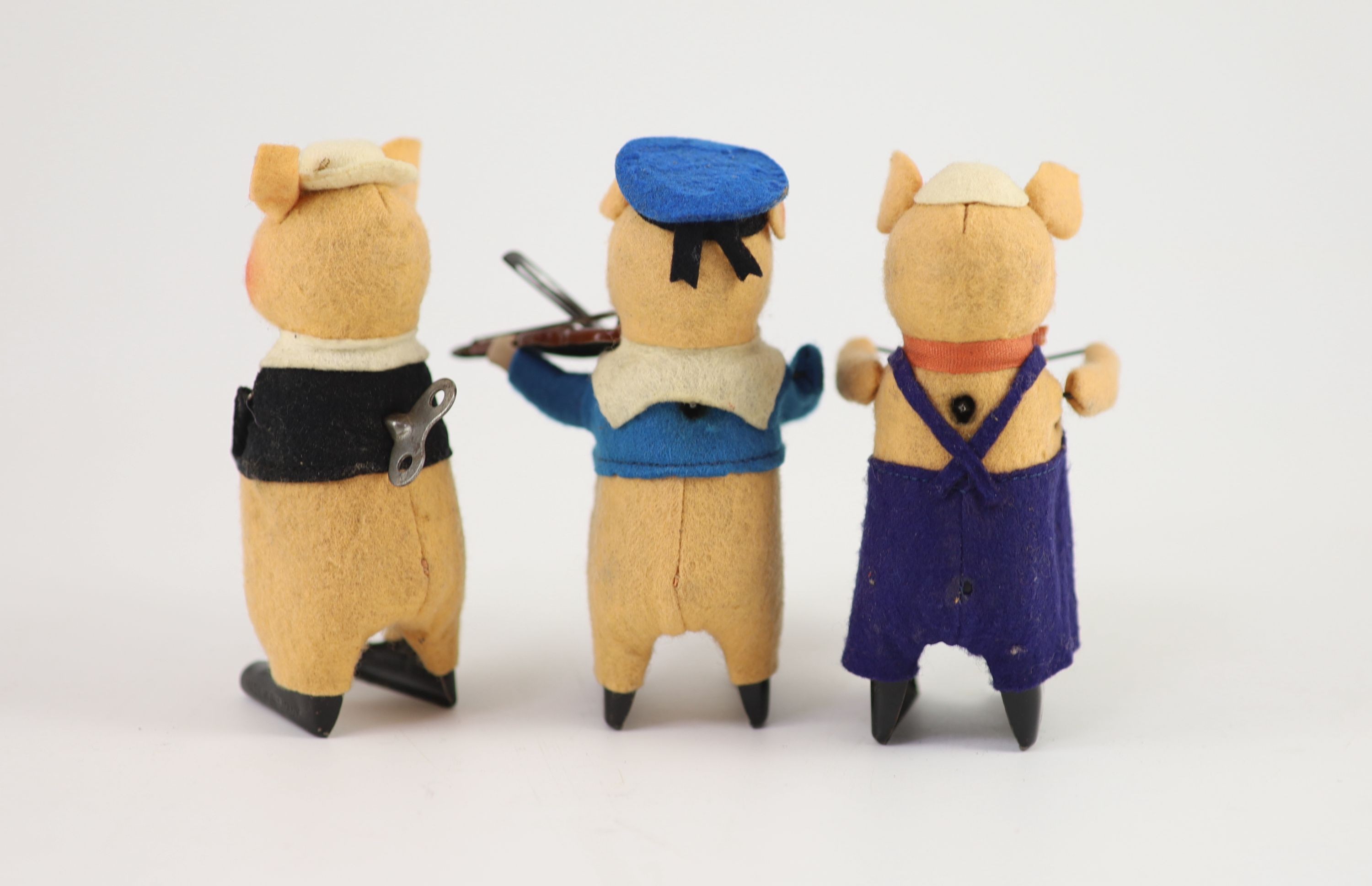 A set of three Schuco tinplate and felt clockwork pig musicians, pre war, tallest 11.5cm